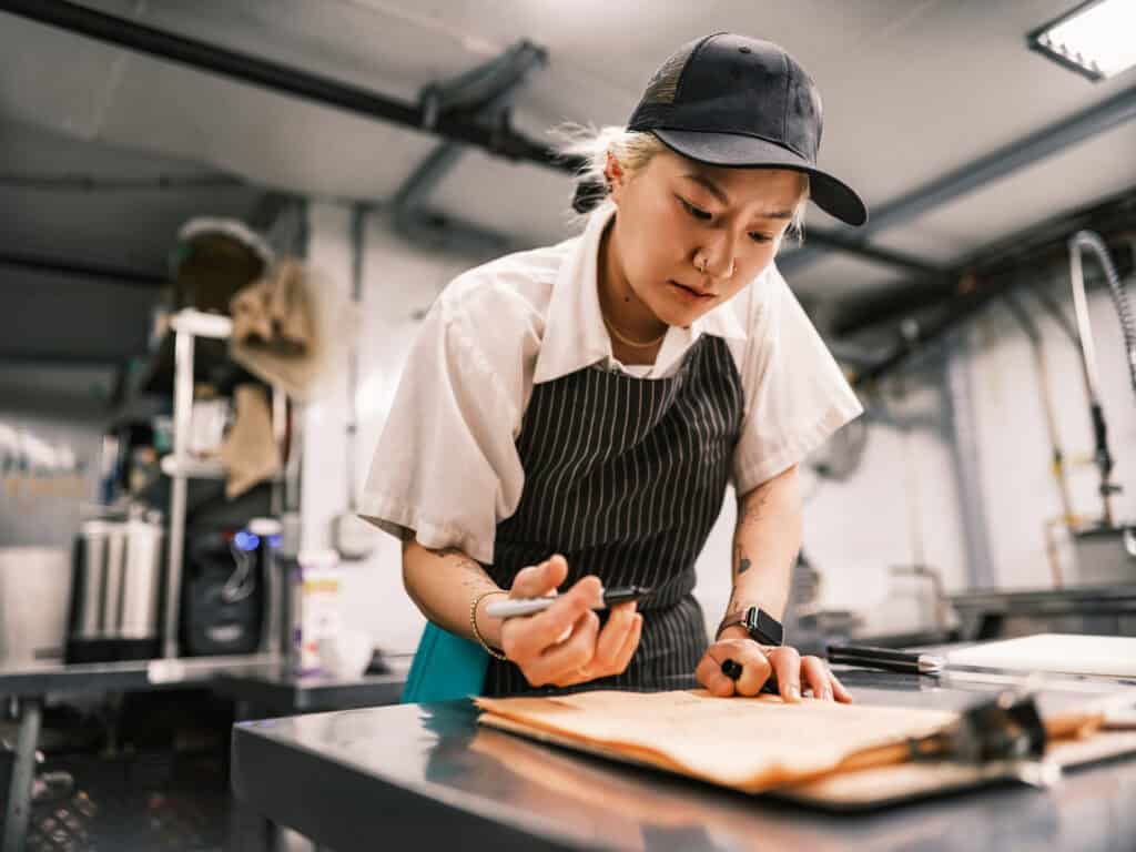 Young female chef is looking at schedule and is feeling tired and stressed