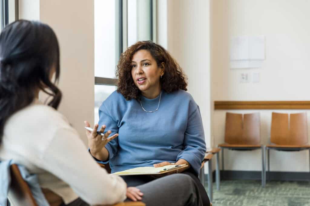 Two people sitting near a window and having a calm discussion