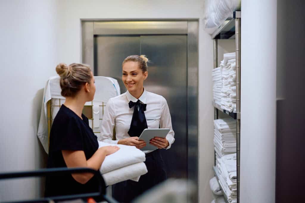 Hotel housekeeping staff and supervisor smiling and talking