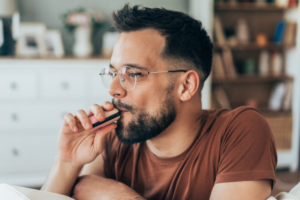 A man relaxing and vaping at home