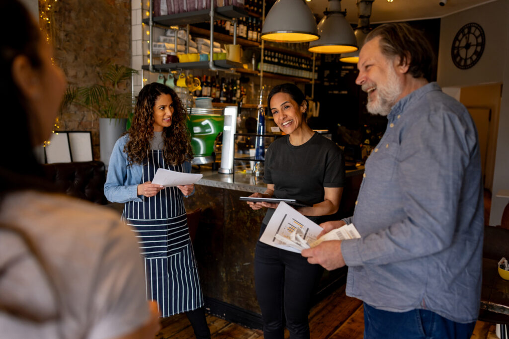 Cafe manager and staff smiling and talking