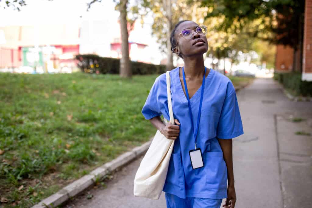 Young nurse wearing scrubs going for a relaxing walk outside
