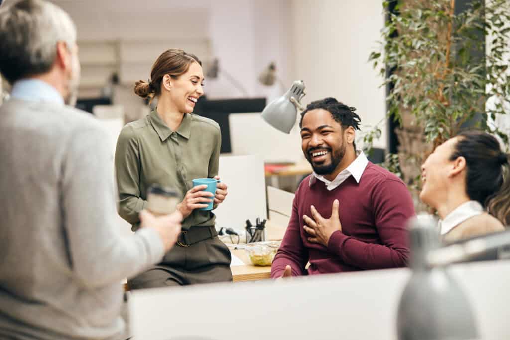 A diverse group of coworkers having a lively, casual conversation in the office