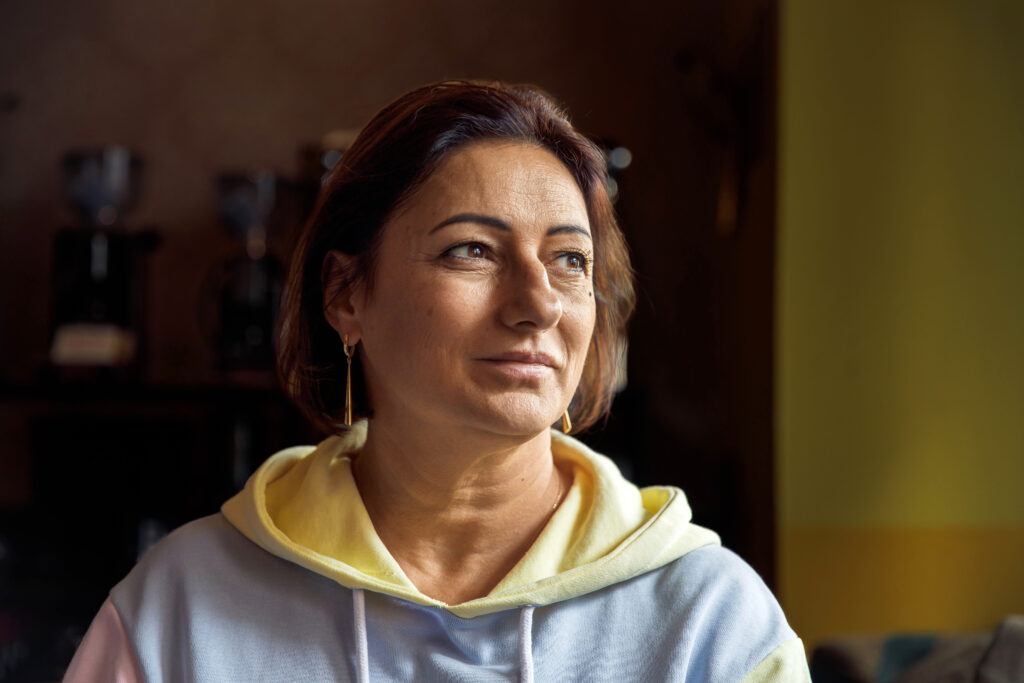 Thoughtful woman in cozy sweatshirt looking away in soft natural light