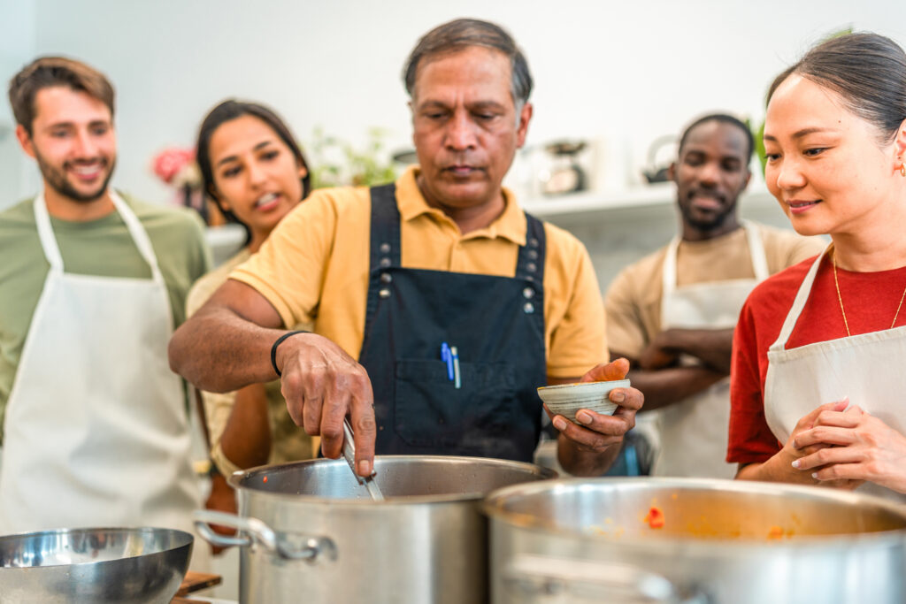 A diverse group of workers cooking together in a community kitchen