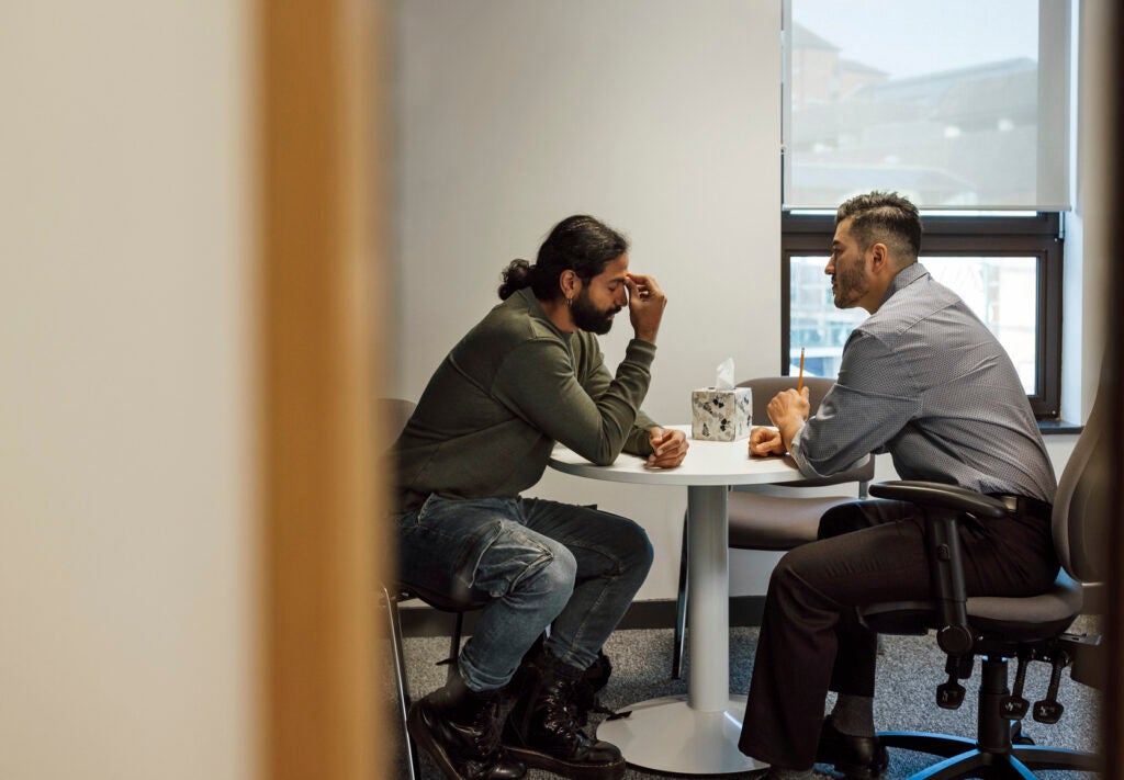 Social service worker listening to man experiencing a crisis