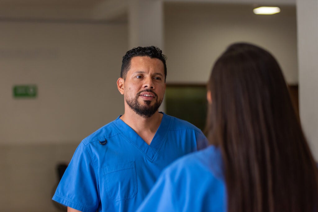 Male nurse having a serious conversation with a colleague.