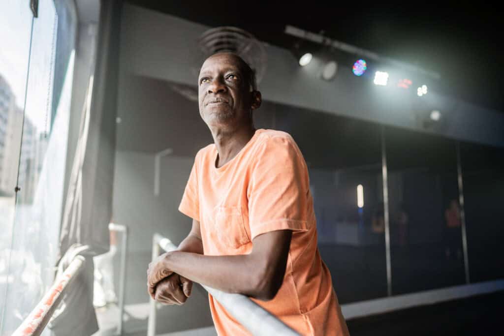 Stage hand taking a break, looking out window and thinking.