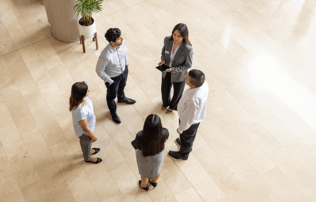 Hotel workers standing in the lobby having a discussion.