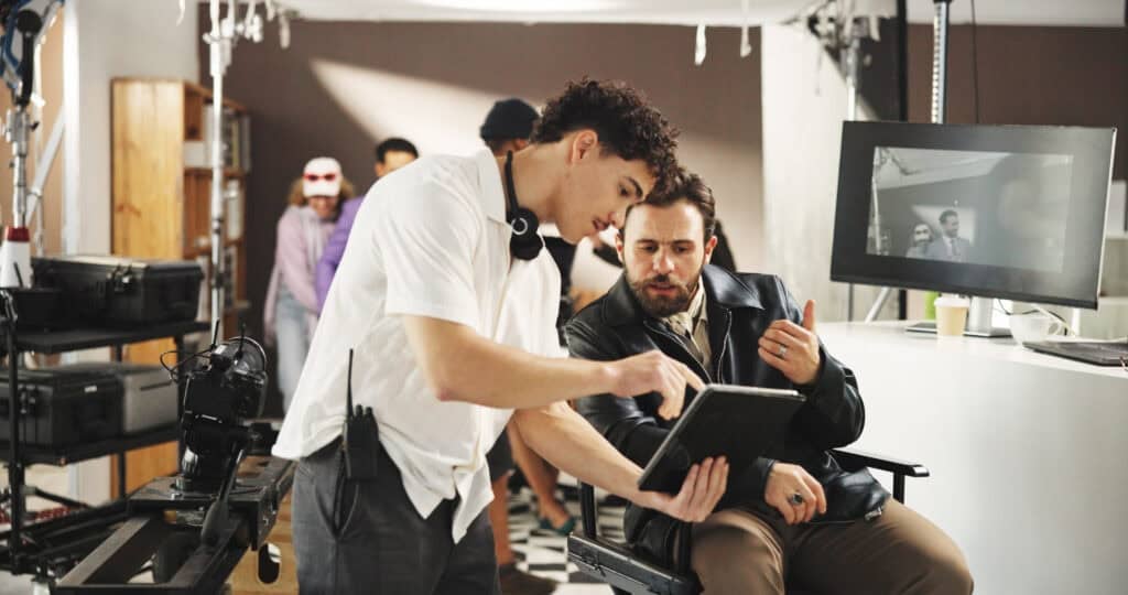 Director talking to assistant on film set. Director looks frustrated.