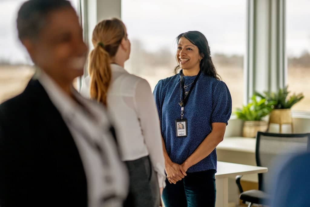 Senior counsellor standing and talking to a worker in the hallway.