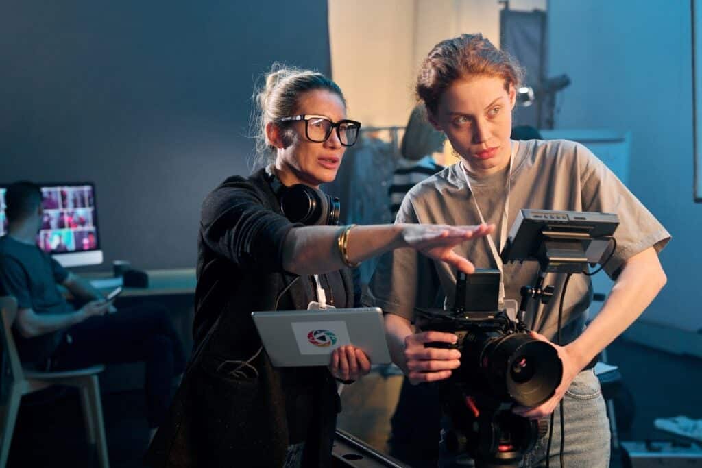 Female director talks to camera operator about filming a scene.