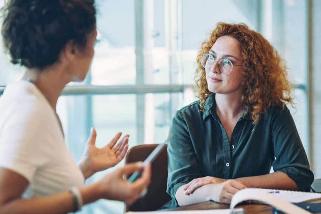 Worker listening to a colleague talk to them about an issue.