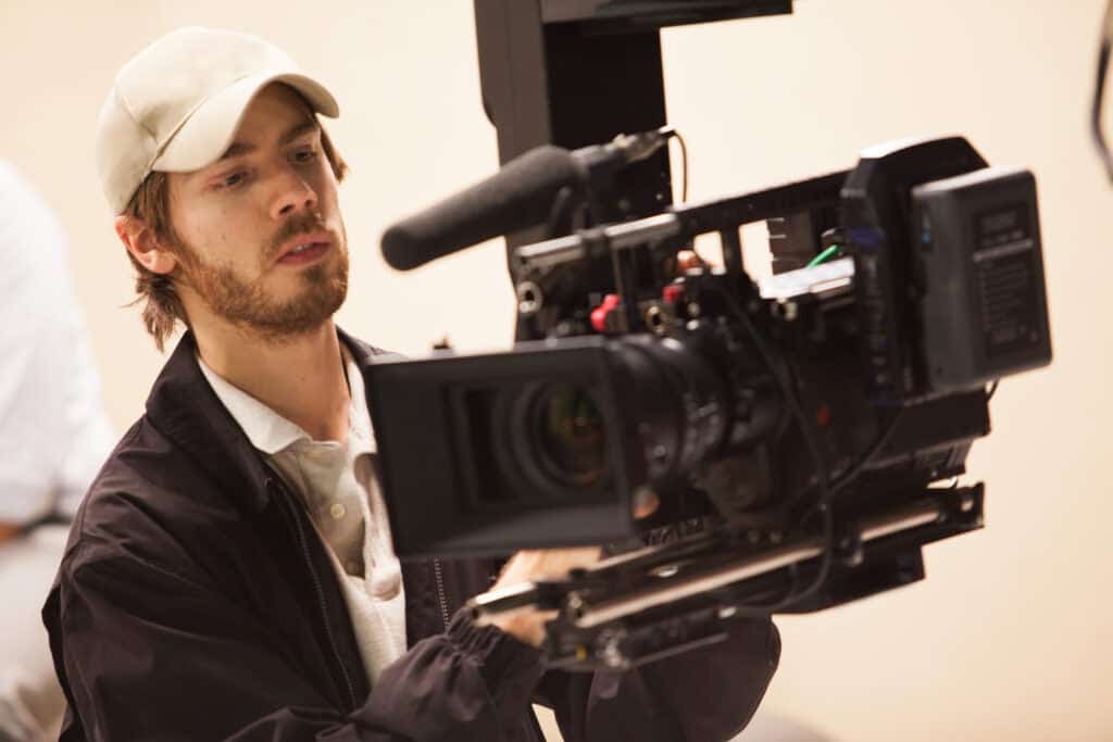 Young man operating a camera on a film set.