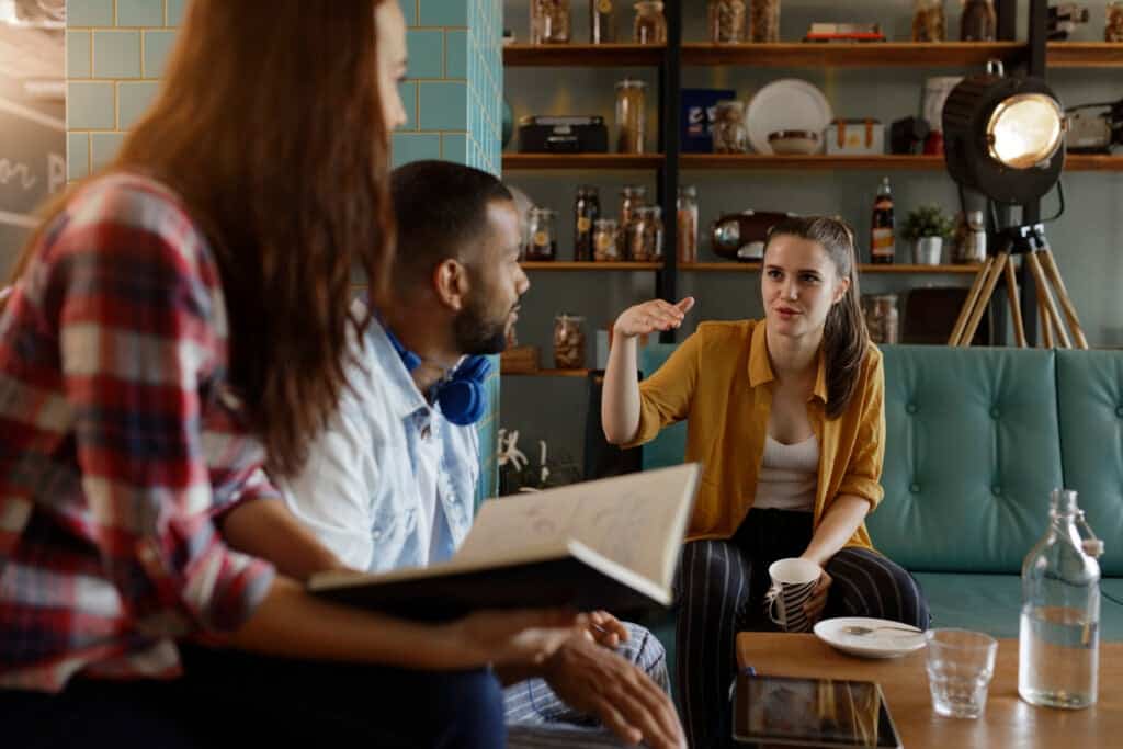 Actors and writer discussing a scene on set.
