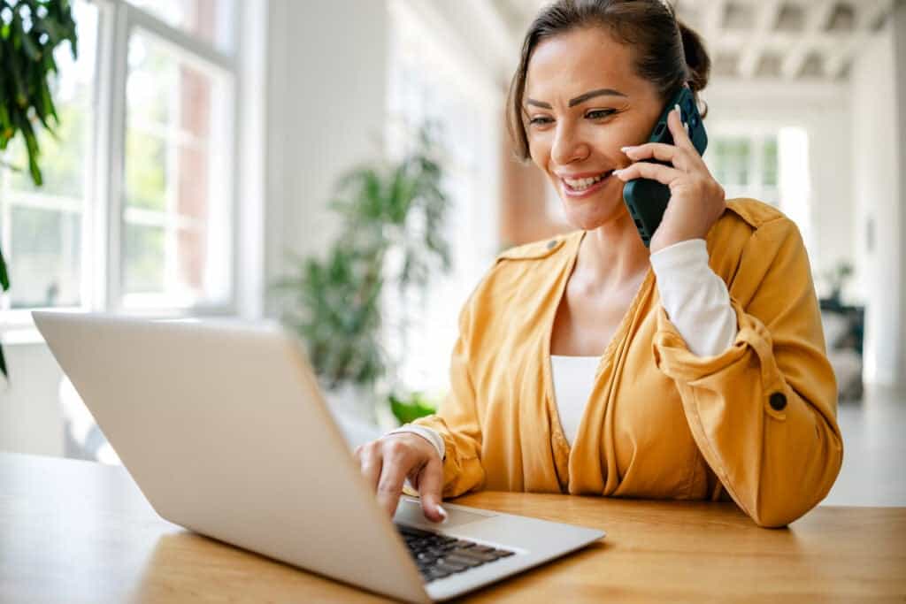 Social worker sitting at her desk talking on the phone to a colleague