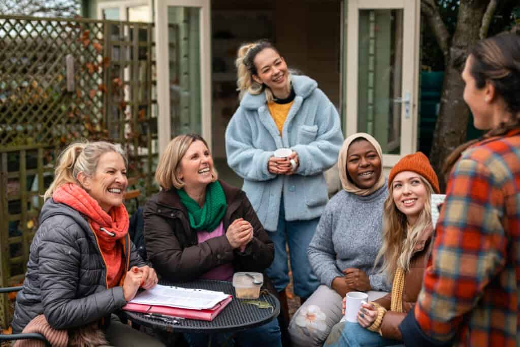 Group of volunteers laughing and talking while taking a coffee break.
