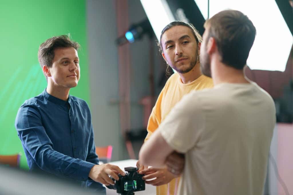 Creative workers talking behind the scenes on a video shoot.