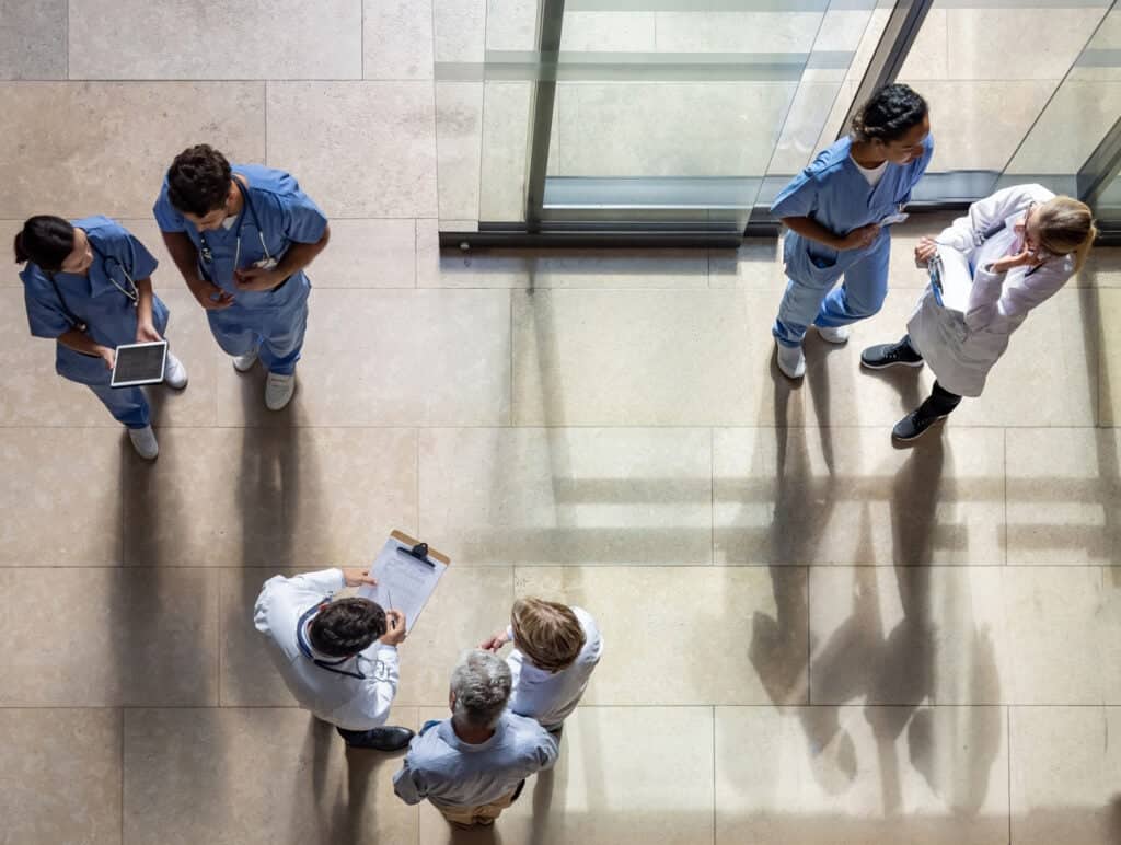 Colleagues talk in a busy entrance at a medical facility