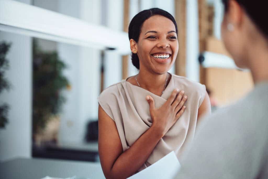 Woman Smiling and Expressing Gratitude During a Conversation